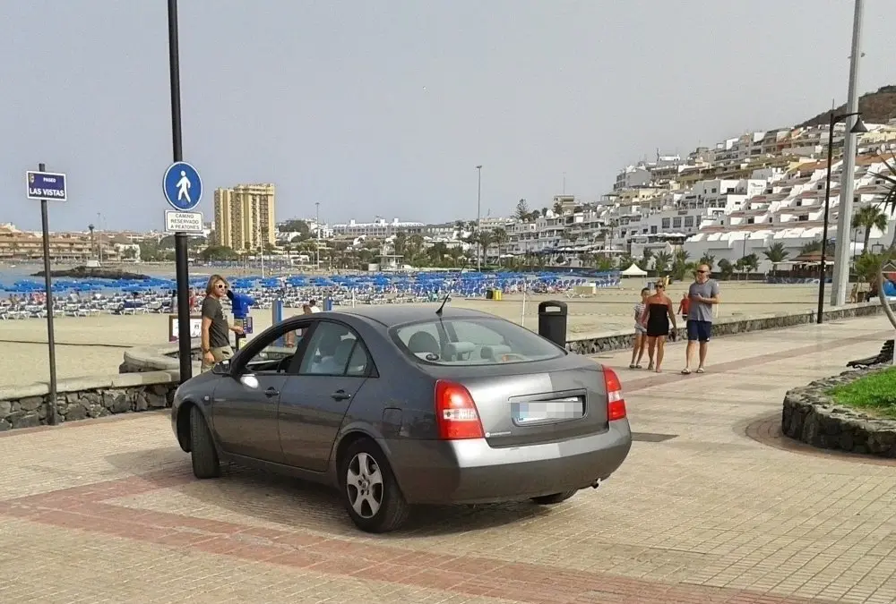 Unos turistas parecen sorprendidos ante el avance de un veh&iacute;culo por el peatonal de Playa de Las Vistas_Fotor