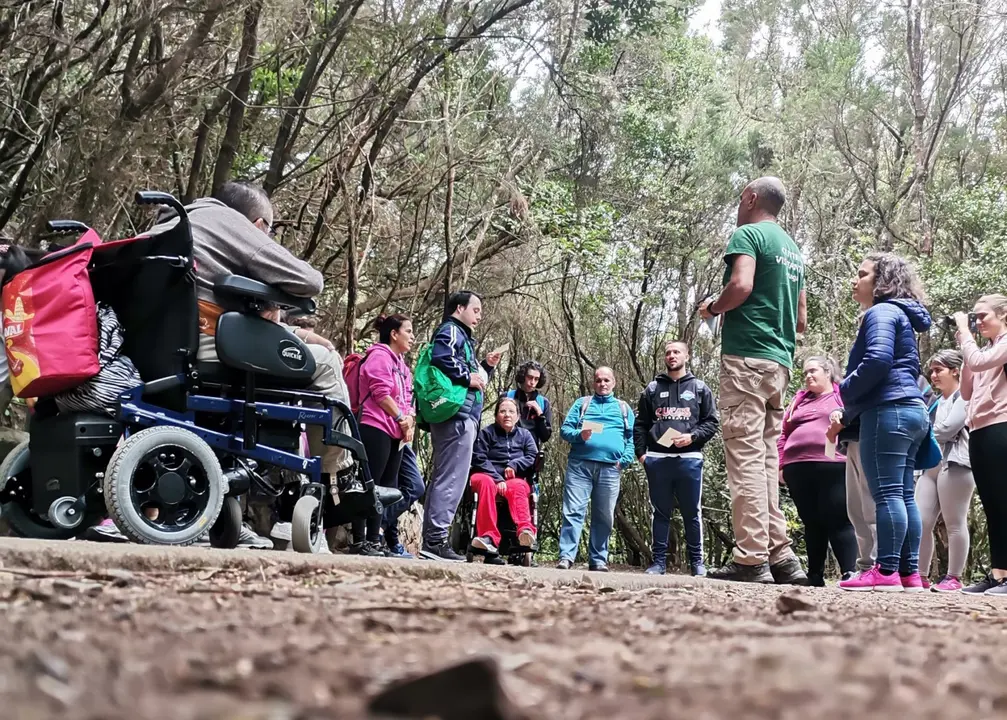 El Centro de Visitantes de Cruz del Carmen ofrece rutas por Anaga para personas con diversidad funcional
En el Parque Rural existen dos recorridos adaptados, el tramo 1 del sendero de los sentidos y el sendero accesible de la Pista de las Hiedras
El Centro de Visitantes de Cruz del Carmen, en el Parque Rural de Anaga, ofrece desde la entrada de la primavera la segunda edici&oacute;n del programa Ruta Pasapanaga, una iniciativa que propone un recorrido por el tramo adaptado de la Pista de las Hiedras en el que personas con diversidad funcional pueden adentrarse en el coraz&oacute;n del Monteverde para conocer los valores naturales y culturales del Parque Rural de Anaga y as&iacute; poder entender su pasado, su presente y la importancia que tiene su conservaci&oacute;n. Todo ello a trav&eacute;s de actividades conducidas por los gu&iacute;as del parque en las que la participaci&oacute;n y el uso de los sentidos son claves.

&ldquo;La atenci&oacute;n a la diversidad es un reto en la gesti&oacute;n de los espacios naturales, es por ello que tanto en Anaga como en otros espacios naturales estemos implementando tramos o senderos completos adaptados a necesidades especiales&rdquo;, ha indicado la consejera de Gesti&oacute;n del Medio Natural, Isabel Garc&iacute;a. En el caso del Parque Rural de Anaga, &ldquo;el equipo de gu&iacute;as del Centro de Visitantes de Cruz del Carmen desarrolla un interesante trabajo con asociaciones y grupos que lo solicitan para poder acercar a la ciudadan&iacute;a ofertas accesibles relacionadas con este entorno tan exclusivo como es el macizo de Anaga&rdquo;, se&ntilde;al&oacute; la consejera.

El recorrido de aproximadamente dos kil&oacute;metros ida y vuelta y sus paradas permiten comprender como la palabra Anaga contiene todos los elementos que hacen de este paisaje un lugar &uacute;nico y especial. A lo largo de los &uacute;ltimos dos meses los gu&iacute;as del centro de visitantes han realizado esta actividad con varios colectivos y asociaciones como Coordicanarias, Asocide, conformado por personas con sordoceguera, Asmipuerto, que atiende a personas con diferentes tipos de diversidad funcional, Funcasor, personas sordas del centro residencial &ldquo;En compa&ntilde;&iacute;a&rdquo;, y Cruz Roja de Icod y Tacoronte, con personas usuarias del proyecto de Atenci&oacute;n a cuidadores/as de pacientes con discapacidad.

Desde el parque se ha hecho un gran esfuerzo para hacer accesible el territorio y su disfrute a todas las personas. Existen dos senderos adaptados como son el tramo 1 del sendero de los sentidos y el sendero accesible de la Pista de las Hiedras. 

La iniciativa de la ruta guiada Pasapanaga pretende ser un paso m&aacute;s en esta direcci&oacute;n acercando la Educaci&oacute;n Ambiental y la interpretaci&oacute;n del patrimonio a las personas que habitualmente suelen tener m&aacute;s dificultades para hacerlo.