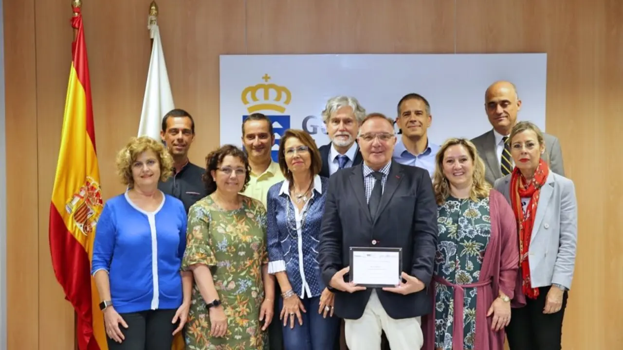 El consejero, portando el premio, con el equipo de Primaria de la Direcci&oacute;n Gral de Programas Asistenciales_Fotor