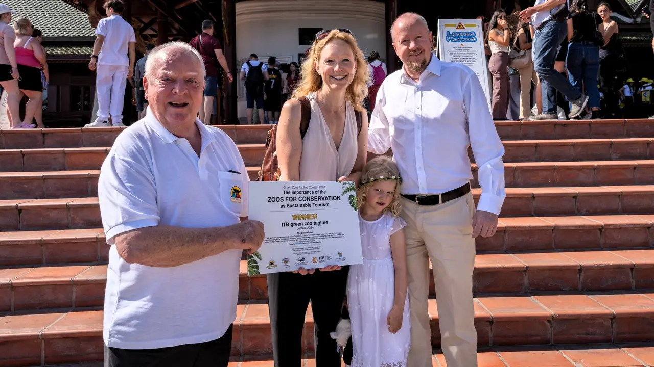 Wolfgang Kiessling posa junto a la ganadora del concurso y su familia.